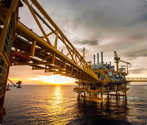Offshore drilling platform at sea at sunset
