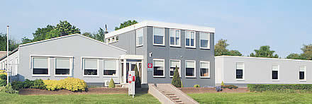 Vooraanzicht THN-pand met moderne grijze gevel en tuin in zomerse setting