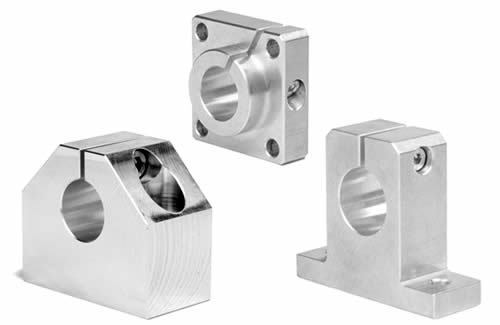 Trois blocs d'essieu en aluminium de différentes formes avec trous de montage