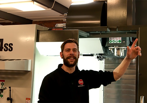 Medewerker van THN wijst omhoog voor freesmachine