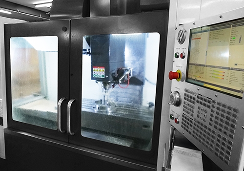 CNC-freesmachine in bedrijf met zicht op bedieningspaneel en freesproces