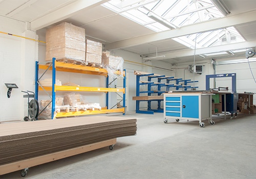 Inpakruimte met werkbanken, rekken en verpakkingsmateriaal voor precisie-assen