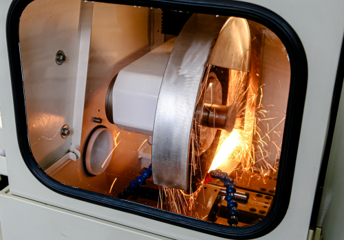 Slijpmachine met vonken tijdens bewerking in gesloten kast