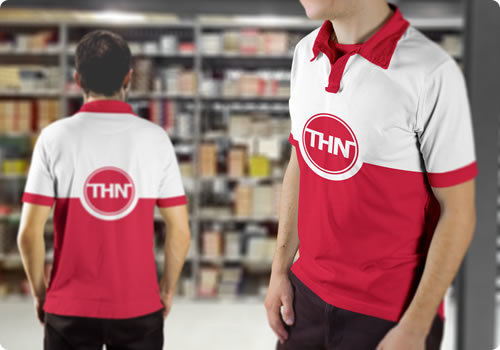 Twee THN-medewerkers in rood-wit bedrijfsshirt staan in een magazijn met voorraadstellingen